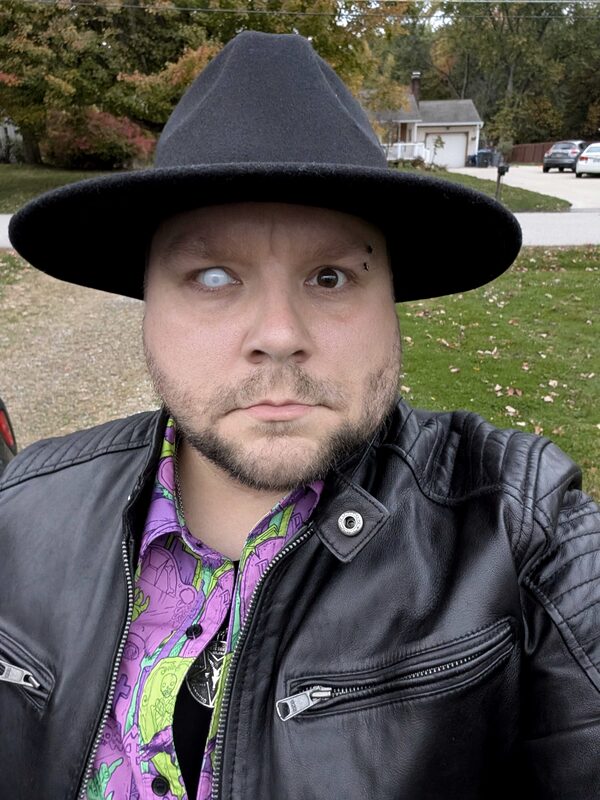 Travis Loudin, programmer and creator of travisloudin.com, in a black wide-brim hat and leather jacket